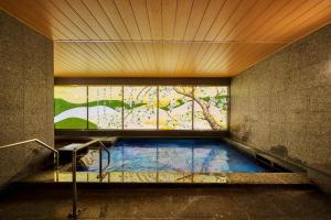 a swimming pool in a room with a window at Daiwa Roynet Hotel Nara Natural Hot Spring in Nara