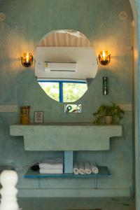 a bathroom with a mirror and a sink with towels at One At Goa in Canacona