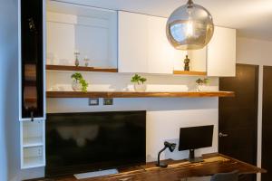ein Wohnzimmer mit einem TV und einem Schreibtisch mit einer Lampe in der Unterkunft Apartamento a unas cuadras de Condado Concepción Carretera a El Salvador in Guatemala + 26 Fotos