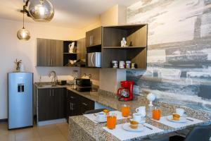 eine Küche mit einem Tisch und einem Kühlschrank in der Unterkunft Apartamento a unas cuadras de Condado Concepción Carretera a El Salvador in Guatemala