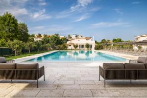 una gran piscina con 2 sofás y un patio en Borgopetra Resort en Numana