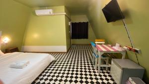a room with a bed and a desk with a tv at พิมานอินทร์ รีสอร์ท in Ban Phang Khwang Tai