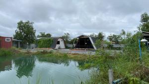 a group of tents next to a body of water at พิมานอินทร์ รีสอร์ท in Ban Phang Khwang Tai