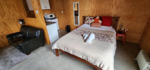 a small bedroom with a bed and a kitchen at Beautiful Rural Oasis in Upper Hutt