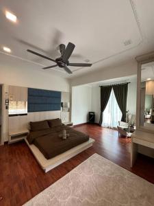 1 dormitorio con 1 cama y ventilador de techo en Green Homestay en Nilai