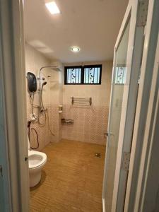 a bathroom with a toilet and a shower in it at Green Homestay in Nilai