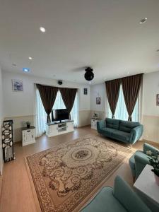 a large living room with a couch and a television at Green Homestay in Nilai