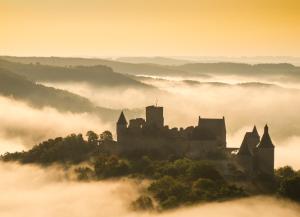 a castle on a hill in the fog at LeafMaxi - Camping du Nord in Bourscheid