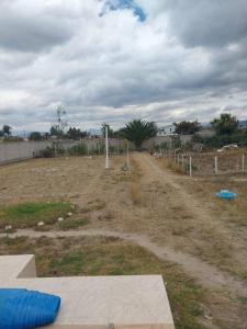 a dirt road in a field with a fence at Departamento moderno y amoblado in Quito