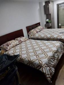 a bedroom with two beds and a table in it at Departamento moderno y amoblado in Quito