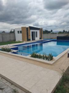 a large swimming pool in front of a house at Departamento moderno y amoblado in Quito
