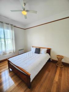 a bedroom with a bed with a ceiling fan at Three Bedrooms Hermay Cottage in Invermay