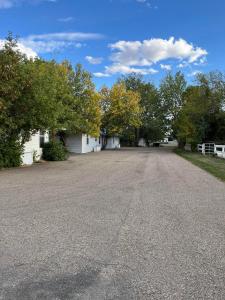 an empty driveway in front of a house at Bluebird Motel in Claresholm