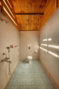 bagno con servizi igienici e soffitto in legno di Zen Cottages ad Agonda