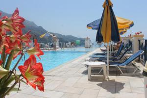 a pool with chairs and umbrellas and a swimming pool at Lido Sofia Apartments in Agios Gordios