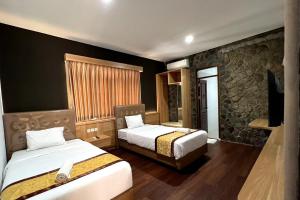 a hotel room with two beds and a flat screen tv at Jatiluhur Valley Resort in Purwakarta