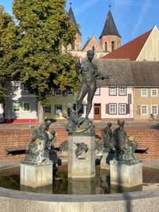 una estatua en medio de una fuente en una ciudad en Apartment in Aken an der Elbe, en Aken