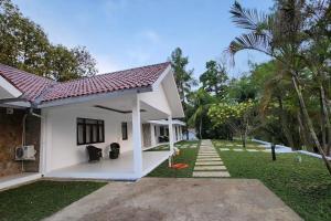a small white house with a yard with a lawn sidx sidx sidx at Jatiluhur Valley Resort in Purwakarta