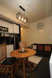 a living room with a wooden table and a kitchen at Erwanos Crib 2 Bedroom Condo with Balcony in Naga