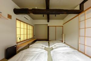 a large bed in a room with large windows at 奥阿賀七名庵　らくら in Aga
