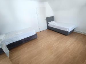 Duas camas num quarto com piso em madeira em FMI29,4Zimmer Accommodation em Raunheim