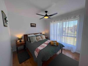a bedroom with a bed and a ceiling fan at Chillin at Adaminaby FSC home in Adaminaby in Adaminaby