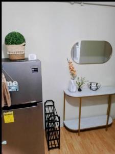 een keuken met een koelkast en een tafel met een spiegel bij Cozy Condo in Davao City