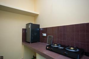 a bathroom with two sinks on a wall with brown tiles at Reunion Regal Villa in Udupi