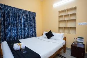 a room with two beds and a window at Reunion Regal Villa in Udupi