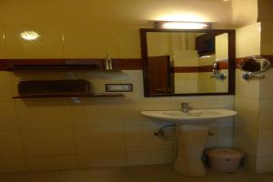 een badkamer met een wastafel en een spiegel bij The Kei Suites in Calcutta