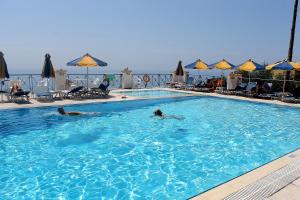 two people swimming in a large swimming pool at Lido Sofia Apartments in Agios Gordios
