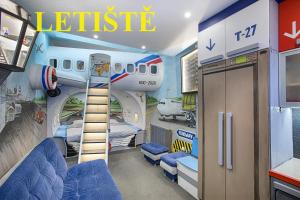 een vliegtuigkamer met een bed en een vliegtuigmuurschildering bij Hotel Kocourkov in Hlinsko