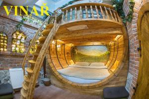 a large wooden barrel room with a spiral staircase at Hotel Kocourkov in Hlinsko