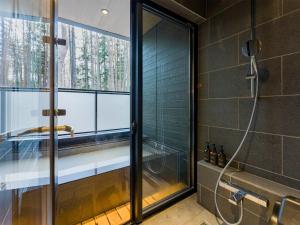 a bathroom with a shower with a glass window at Rakuten STAY VILLA Fuji Kawaguchiko Forest 2LDK with sauna and terrace in Fujikawaguchiko