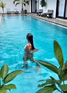 una mujer en el agua en una piscina en D' Art VILLA RETREAT AND SPA, en Tangalle