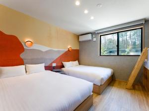 a hotel room with two beds and a window at Rakuten STAY VILLA Fuji Kawaguchiko Forest 2LDK with sauna and terrace-Pet Friendly- in Fujikawaguchiko