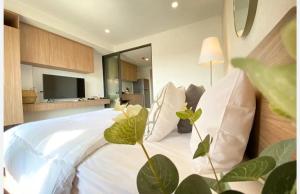 a bedroom with a large white bed with a television at Lahabana Resort in Hua Hin