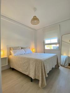 ein weißes Schlafzimmer mit einem großen Bett in einem Zimmer in der Unterkunft Playa Albir in Albir