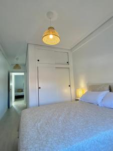 ein Schlafzimmer mit einem großen Bett und einer Leuchte in der Unterkunft Playa Albir in Albir