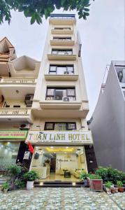 a tall white building with a sign on it at Tuấn Linh Hotel in Ha Long
