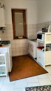 kuchnia z białymi urządzeniami i oknem w obiekcie Apartment Montanelli w Pizie