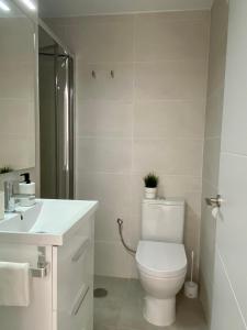 アルビールにあるPlaya Albirの白いバスルーム(トイレ、シンク付)