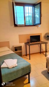 Pokój z łóżkiem i biurkiem z laptopem w obiekcie Apartment Montanelli w Pizie