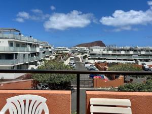 a balcony with two chairs and a view of a city at Апартамент с 1 спальней в La Tejita (El Medano) in Granadilla de Abona