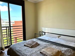 a bedroom with a bed and a large window at Апартамент с 1 спальней в La Tejita (El Medano) in Granadilla de Abona