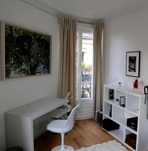 een wit bureau en stoel in een kamer met een raam bij Le Ciel de Paris - Montparnasse & Jardin du Luxembourg in Parijs