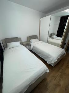 2 camas en una habitación con sábanas blancas en Lilo HOME, en Sibiu
