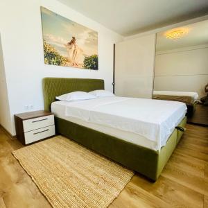 1 dormitorio con 1 cama grande y una pintura en la pared en Lilo HOME, en Sibiu
