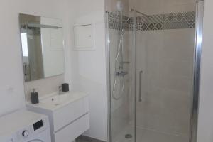 baño blanco con ducha y lavamanos en La Rochelle- Puilboreau Studio tout confort, en Puilboreau