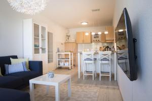 ein Wohnzimmer mit einem Sofa und einem Tisch sowie eine Küche in der Unterkunft Strandhaus Nordseebrandung Fewo B3.4 in Cuxhaven